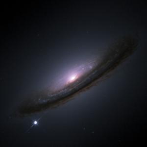 An image of the galaxy NGC 4526 featuring a bright supernova (SN 1994D) in the lower left. The galaxy has a glowing core surrounded by dark, dust-filled spiral arms, creating a striking contrast in the image