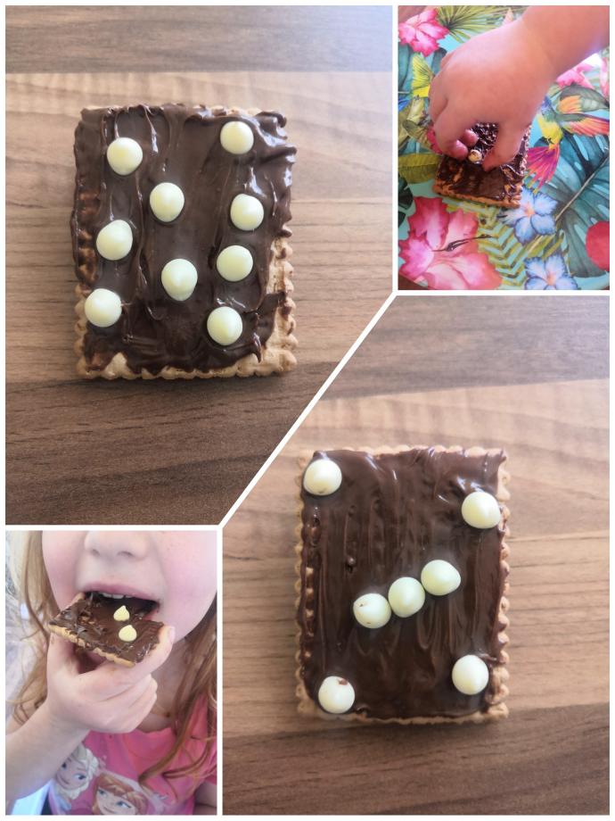 A collage of images showing a biscuit covered in chocolate spread with white chocolate buttons arranged to resemble star patterns. One image shows a child's hand placing a button, and another shows a child taking a bite from the biscuit. The main image features a rectangle-shaped biscuit with chocolate spread and a simple constellation-like arrangement of chocolate buttons.